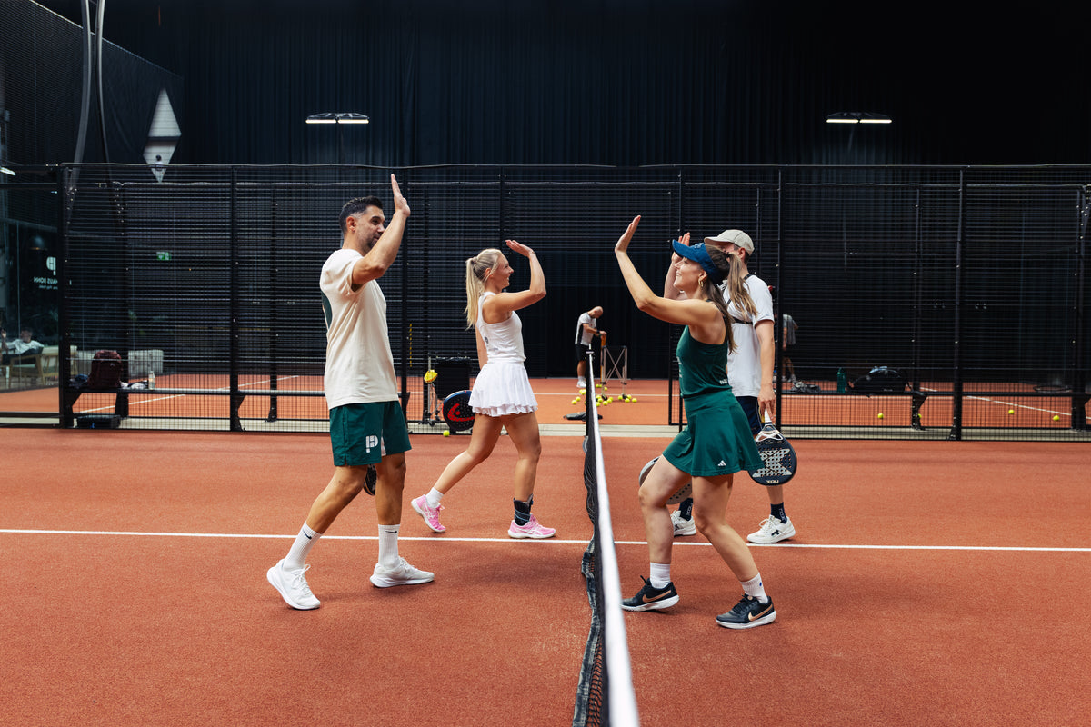 Vier Padel Spieler klatschen sich ab